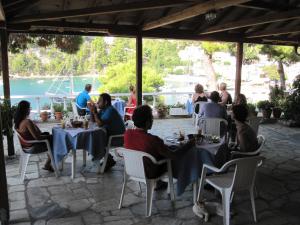 a group of people sitting at tables in a restaurant at Kavos Hotel in Patitiri