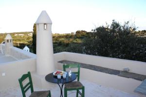 a small table and chairs on a balcony with a lighthouse at Celestia Traditional Houses in Keramoto