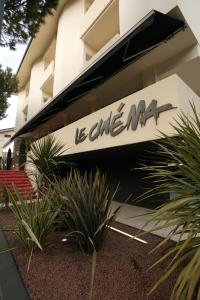 a sign on the side of a building with plants at Hotel Le Cinéma in Gatteo a Mare