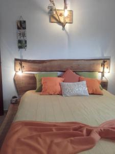 a bed with several pillows on top of it at De Baixo Da Ponte in Biscoitos