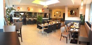 une salle à manger avec des tables et des chaises dans un restaurant dans l'établissement Le Pavillon, à Blois