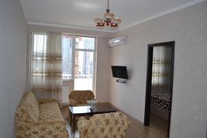 ein Wohnzimmer mit 2 Stühlen, einem Tisch und einem Spiegel in der Unterkunft batumi apartment 173 in Batumi