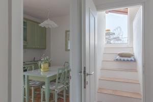 cocina y comedor con mesa y escaleras en Casa Maria, en Tremosine Sul Garda
