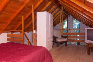 a bedroom with a bed and a tv in a attic at Cabañas El Racó del Bosc in Mar del Plata