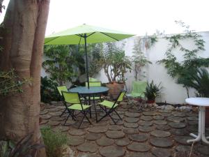 uma mesa e cadeiras com um guarda-sol num pátio em Casa do Jasmim em Sintra