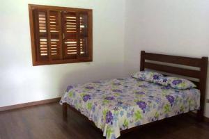 um quarto com uma cama e uma janela em Recanto da Maya em Santo Antônio do Pinhal