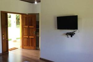 uma sala de estar com uma televisão de ecrã plano na parede em Recanto da Maya em Santo Antônio do Pinhal