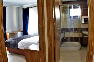 a bedroom with a bed and a glass shower at Turkuaz Apart in Uzungöl +49 photos