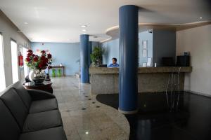 Nova SerranaHotel Calypso的坐在医院大厅柜台上的男人