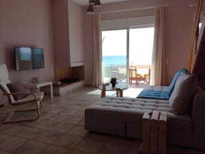 a living room with a couch and a view of the ocean at Dip in the blue - 2 in Agios Georgios