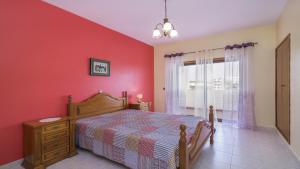 a bedroom with a bed and a red wall at Apartamentos Vista Mar in Armação de Pêra +95 photos