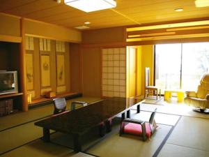 a living room with a table and chairs at Ryokan Beniayu in Nagahama