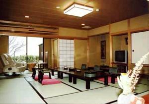 un ampio soggiorno con tavolo e sedie di Ryokan Beniayu a Nagahama