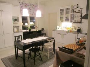 Una cocina y un comedor con mesa y sillas. en Hotelli Huiskankorpi Boutique Hotel, en Nivala