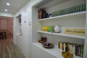 una stanza con scaffali bianchi con libri di Il Giardino a Tivoli