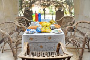 a table with food and fruit on top of it at Grand Museum Guest House in Kafr Abū ʼumaydah