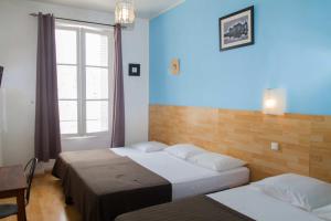 a hotel room with two beds and a window at Le Pavillon in Blois