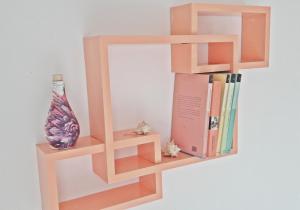 a wooden book shelf with books and a vase at Luka Kokić Apartments in Podgora