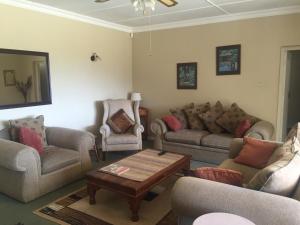 a living room with couches and chairs and a coffee table at Hawley House in Underberg