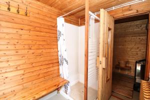 um quarto com paredes de madeira e uma porta de madeira em Höfði Cottages em Dalvík