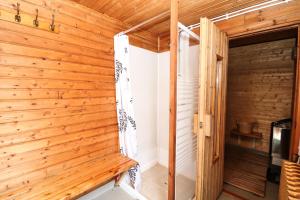 Habitación con paredes de madera y puerta de madera. en Höfði Cottages, en Dalvík