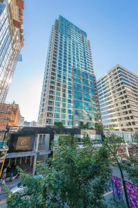 a tall building in the middle of a city at Carmana Hotel & Suites in Vancouver