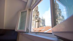 an open window with a view of a church at Hotel Praza Quintana in Santiago de Compostela