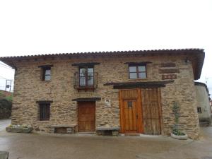 un edificio de piedra con puertas y ventanas de madera en Casa Abuela ★★★, en Grisuela