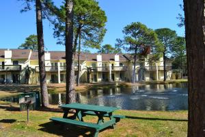 una mesa de picnic frente a un edificio con un estanque en The Links en Myrtle Beach