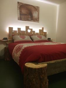 a bedroom with a red bed with a wooden headboard at Atmosphere di montagna in Vermiglio