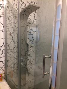 um chuveiro com uma porta de vidro na casa de banho em Guatemala em Buenos Aires
