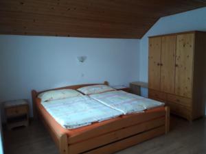 a bedroom with a bed and a wooden cabinet at Rooms-Apartment Renata in Bled