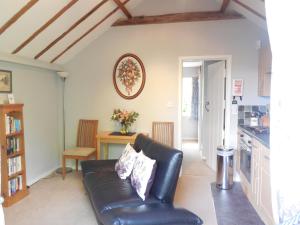a living room with a leather couch and a table at Wishing Well Cottage in Wilmington