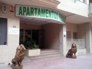 dos estatuas de leones frente a un edificio en Apartamentos Turísticos Fresno en Torrevieja