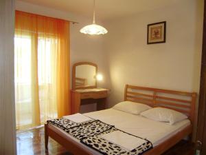 a bedroom with a bed and a mirror and a window at Guest House Adria in Senj