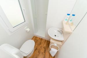 a white bathroom with a toilet and a sink at Mobile Homes Plava Laguna in Pakoštane +48 photos