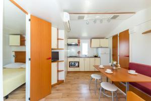 a small kitchen and dining room with a table and chairs at Mobile Homes Plava Laguna in Pakoštane