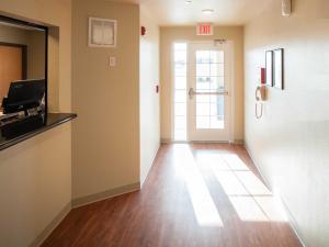 an empty room with a hallway with a door at WoodSpring Suites Junction City in Junction City