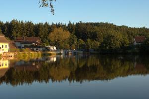 vistas a un lago con casas y árboles en Seegasthof Franz Bolz GBR en Ellwangen