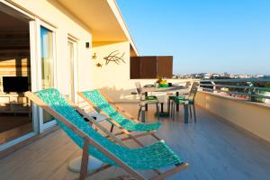 Home Sweet Praia Penthouse في نازاريه: شرفة مع كراسي وطاولة على السطح