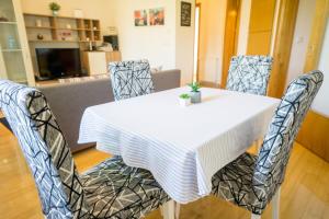 a dining room table and chairs with a white table cloth at Blue Lake Apartment in Zagreb +14 photos