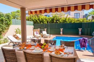 a table with food on it next to a pool at Meloneras Hills 16 With Pool by VillaGranCanaria in Meloneras