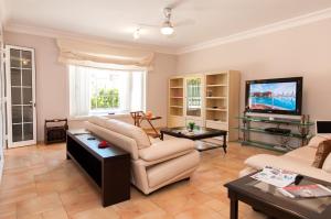 a living room with a couch and a tv at Meloneras Hills 16 With Pool by VillaGranCanaria in Meloneras