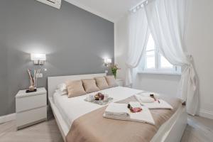 a white bedroom with a bed with two towels on it at Trevi Apartment in Rome