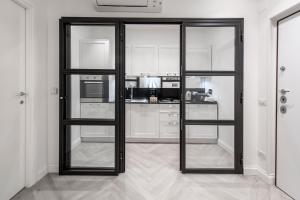 una cucina con porte in vetro con struttura a vetri nera in una stanza di Trevi Apartment a Roma