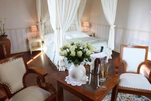 Un dormitorio con una cama y una mesa con un jarrón de flores en Boutique Hotel Dobra Vila Bovec, en Bovec