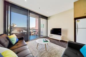 a living room with a couch and a tv at York Apartments in Adelaide