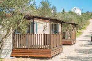 a row of wooden homes on a dirt road at Mobile Homes Plava Laguna in Pakoštane