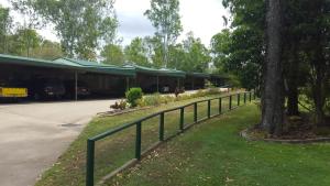a fence in front of a building with a tree at Tiaro Motor Inn in Tiaro +13 photos
