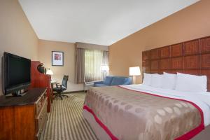 a hotel room with a bed and a flat screen tv at Ramada by Wyndham Columbus North in Westerville